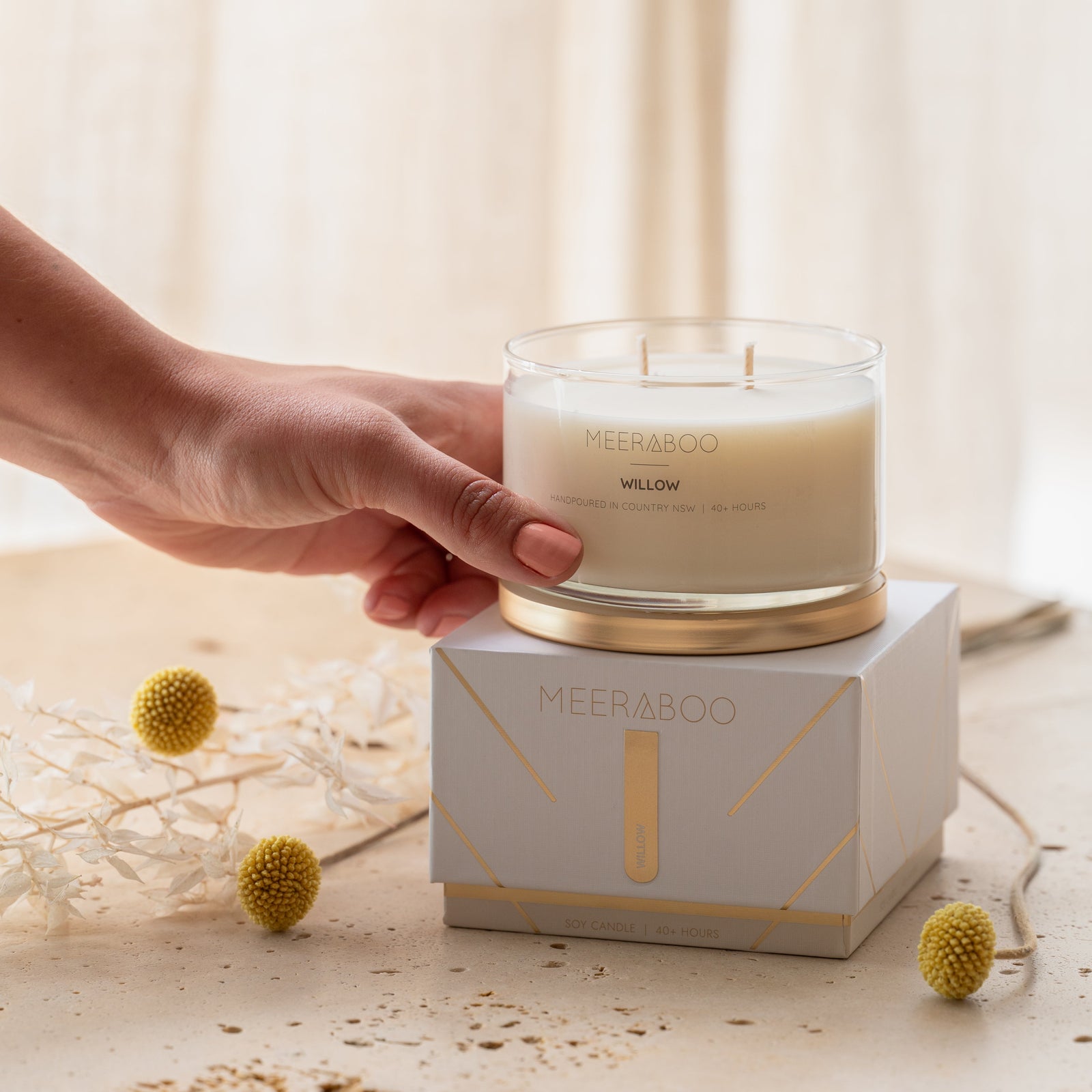 Hand lighting a candle on a neutral background